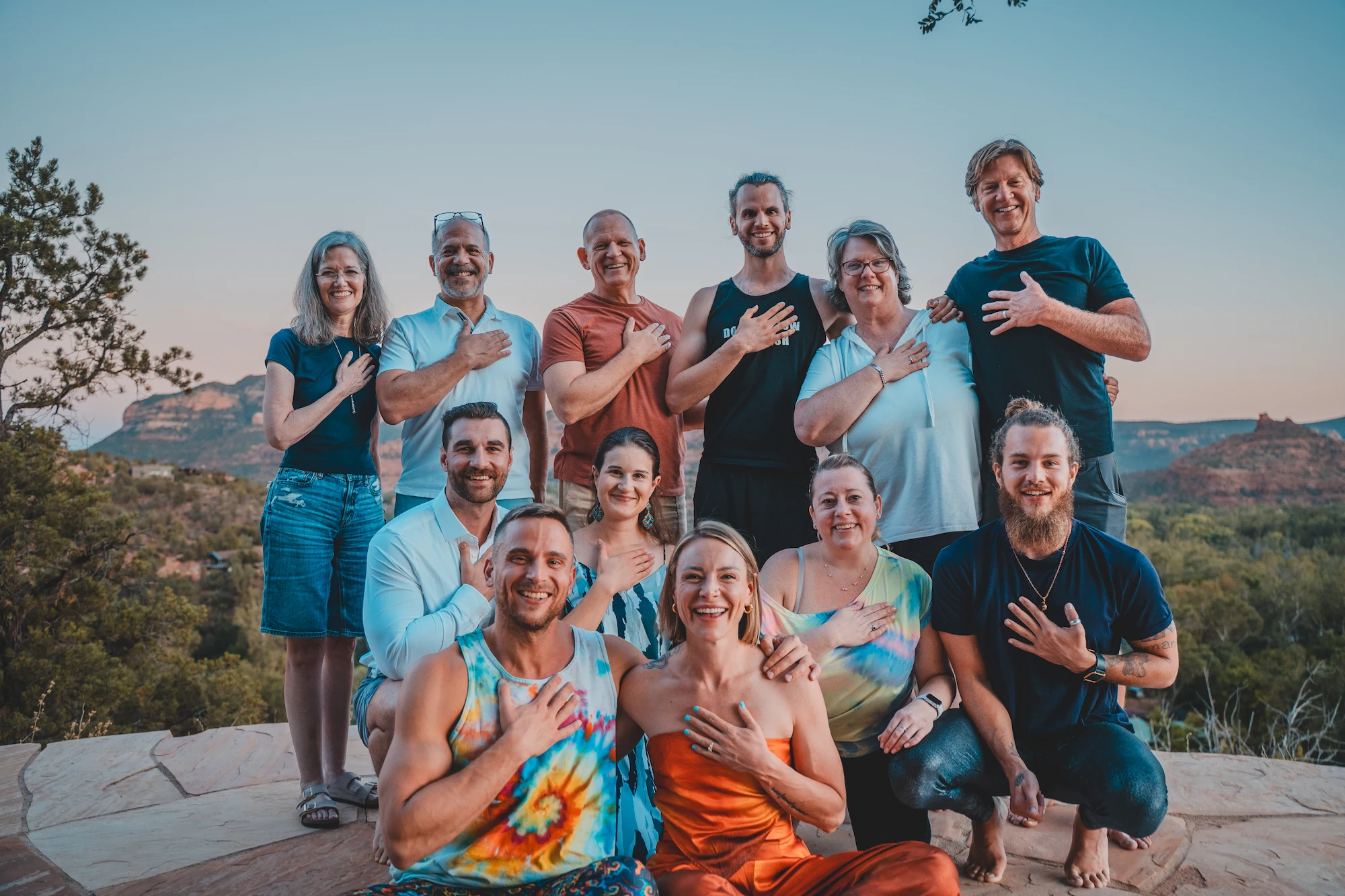 A retreat group standing together at dusk, each with a hand over their heart