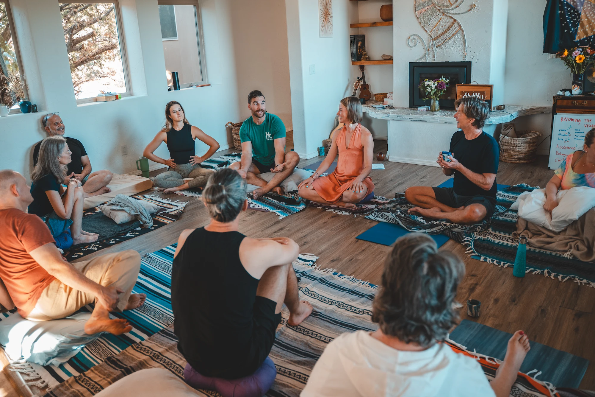 A retreat group sitting in a circle on blankets in the Sky Castle living room