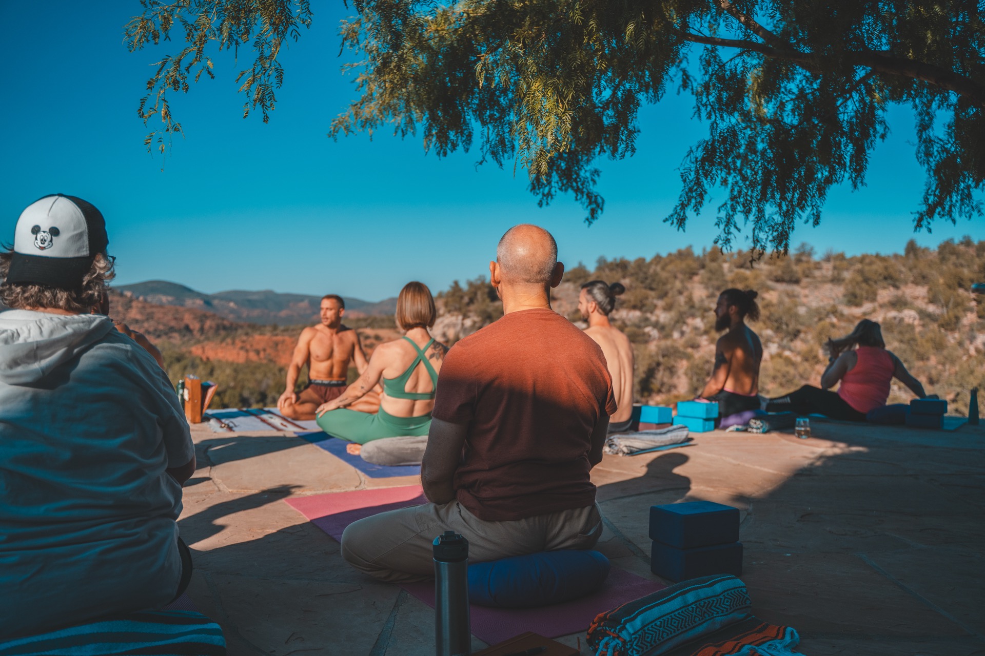 Participants practicing yoga on a stone terrace above the Sedona valley